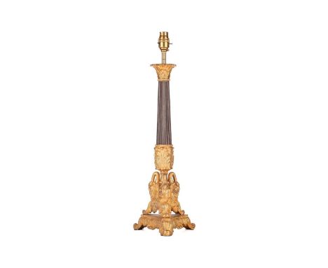A gilt and patinated metal table lamp, 20th century, with composite capital and reeded shaft, the triform base cast with swan