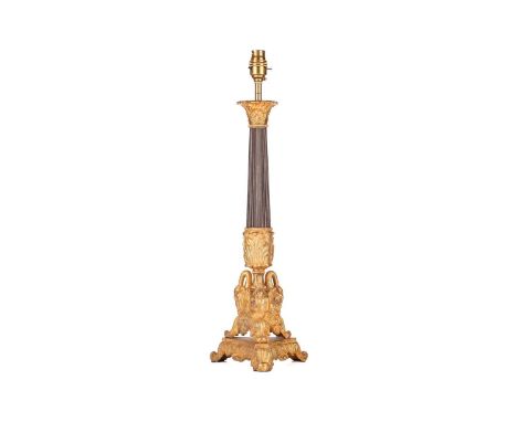 A gilt and patinated metal table lamp, 20th century, with composite capital and reeded shaft, the triform base cast with swan