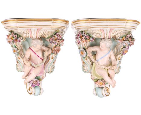 A pair of probably late Dresden porcelain figural wall brackets, late 19th century, each with putti swags of encrusted colour