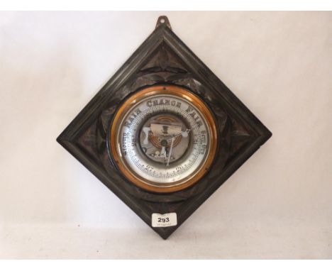 A carved ebonised aneroid barometer. 9' wide