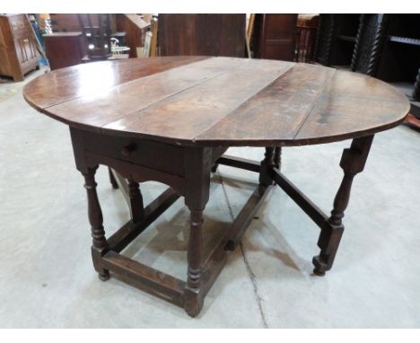 A 17th century joined oak dropleaf table, with two frieze drawers on baluster ring turned legs and square perimeter stretcher