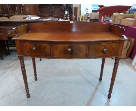 A George IV mahogany bow-breakfronted washstand, the galleried top over three frieze drawers on ring turned legs. 48' wide