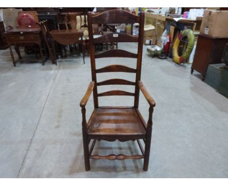 A 19th century oak clisset elbow chair with unusually high ladder back