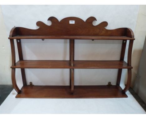 A mahogany hanging wall shelf, brass line inlaid, with fret carved surmount. 35' wide