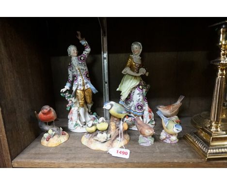 A pair of Continental porcelain figures of a shepherd and shepherdess, 27cm high; together with three Royal Worcester birds; 