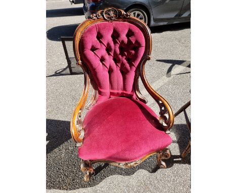 A Victorian walnut and button upholstered open armchair.&nbsp; 