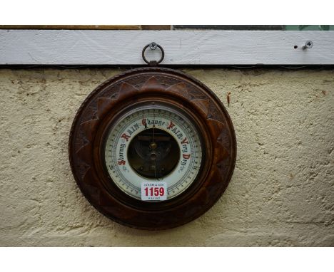 A circa 1900 carved walnut aneroid barometer,&nbsp;21.5cm diameter. 