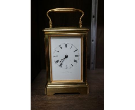 An antique brass carriage timepiece, the enamel dial inscribed 'Dent, Strand, London', height including handle 17cm, with win