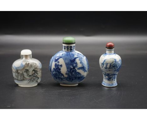 Three Chinese snuff bottles and covers, comprising: a large blue and white example, with Qianlong four character mark to base