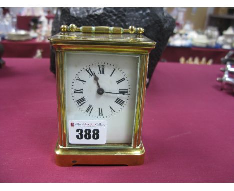 A Brass Carriage Clock, with black Roman numerals, to white enamel dial, swing handle 7.5cm wide plus key.