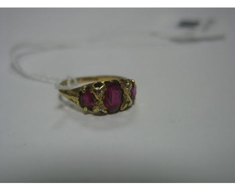 A Victorian 18ct Gold Ruby and Diamond Ring, the graduated stones claw set between old cut diamond accents, Birmingham 1900. 