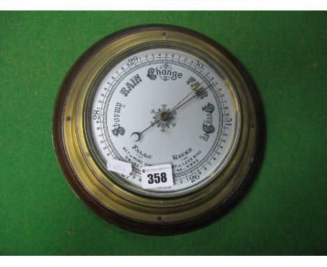 A British Made Barometer, silvered dial with brass casing on a circular mount, diameter of face 15cm