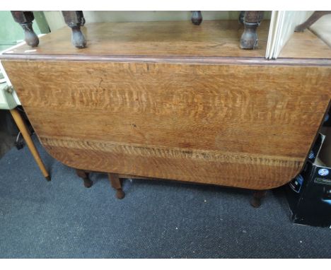 A mid 20th century oak drop leaf dining table on gate legs