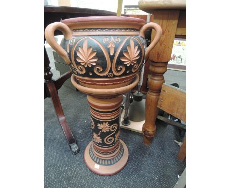 A terracotta planter on stand and polished stones