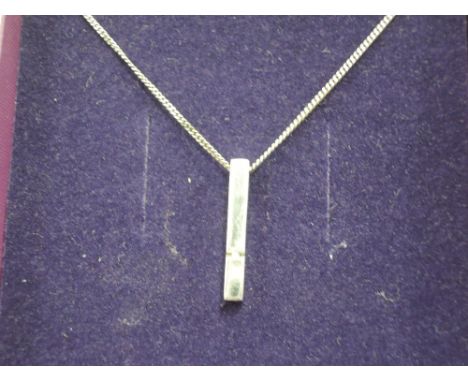 A white metal pendant set with a diamond chip on a white metal chain stamped 925