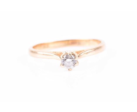 A yellow metal and solitaire diamond ring, set with a round-cut diamond of approximately 0.20 carats, shank unmarked, size K 