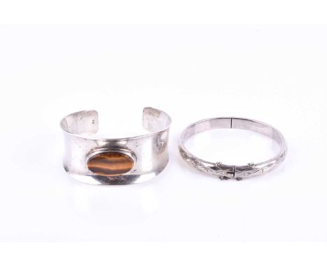 A Danish silver cuff bangle, inset with an oval tigers eye, internal diameter approximately 6 cm, together with a silver bang