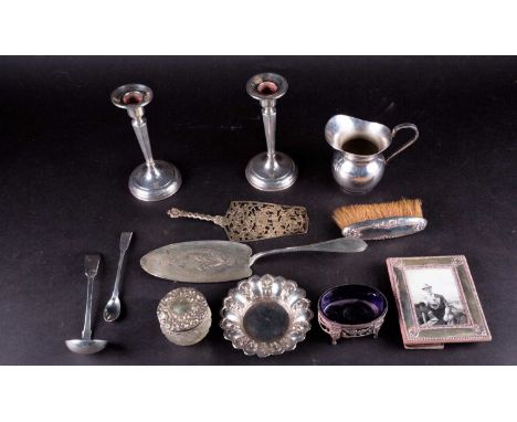 A mixed group of silver items to include a Continental pastry slice with pierced decoration, a pair of sterling silver candle