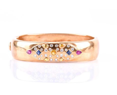 A yellow metal, diamond, and gemstone bangle, inset with round brilliant-cut diamonds, mixed-cut blue and yellow sapphires, a