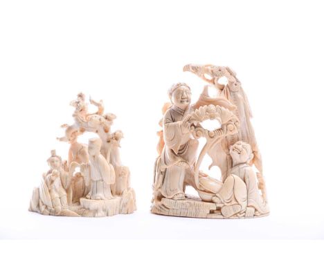 Two Chinese carved ivory figure groups, early 19th century, one depicting two figures beneath a pine tree,summoning a bat fro