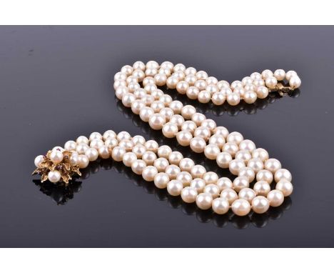 A triple strand graduated pearl necklace, fastened with a yellow metal, pearl, and ruby cluster clasp, marked 14K, shortest s