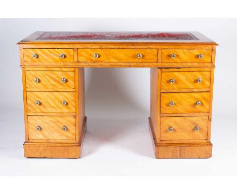 A Victorian satinwood veneered pedestal desk, the red leather inset top over three frieze drawers, supported on pedestals, ea