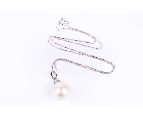 A silver, cubic zirconia, and pearl pendant, set with a large South Sea pearl, approximately 15 mm diameter, beneath a CZ-set