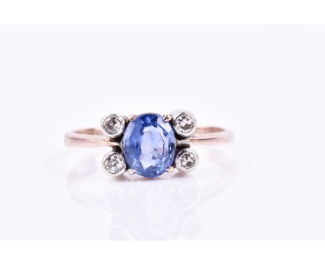 A diamond and sapphire ring, set with a blue sapphire of approximately 1.20 carats, four-claw set, flanked with four collet-s