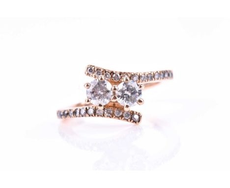 A 14ct rose gold and diamond crossover ring, set with two round-cut diamonds of approximately 0.30 carats each, I2-3 clarity,