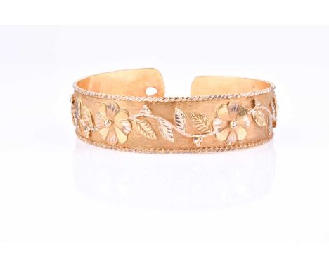 An unusual yellow metal bangle, with raised floral and foliate decoration, with press button fasten, internal diameter 5.8 cm