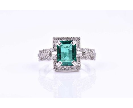 An emerald and diamond cocktail ring, set with a mixed rectangular-cut emerald, with a stylised link-designed border and shou