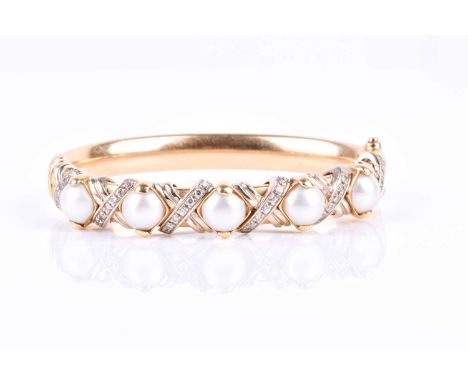 An Italian yellow metal and pearl bangle, set with five round white cultured pearls within a crossed border of round-cut cubi