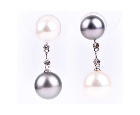 A pair of white and grey South Sea and Tahiti pearl drop earrings, one with a smaller grey pearl above a larger white pearl, 