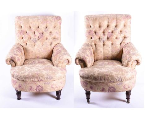 A pair of large button back armchairs in the manner of George Smith, each upholstered in floral fabric, on turned front legs 