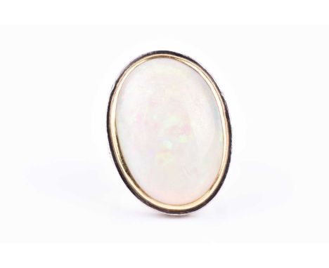 A mid to late 20th century yellow metal and opal cocktail ring, set with a large oval cabochon opal, measuring approximately 