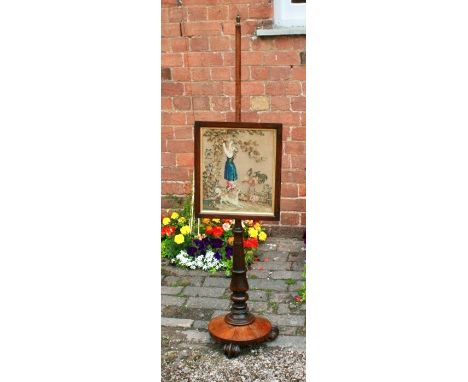An early Victorian rosewood pole screen, circa 1850, mounted with a brass finial on a turned pole holding a glazed tapestry s