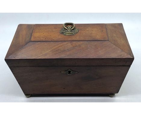 A mid 19th century mahogany tea caddy, sarcophagus shaped, brass fruit basket terminal escutcheon with rung, brass swagged di