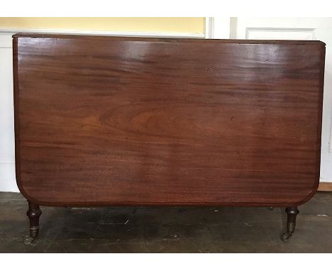 A mahogany drop leaf dining table with gate leg action, on taperered turned legs and brass casters, circa 1940, Retracted dim