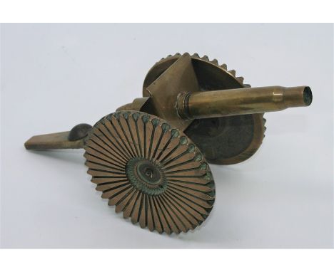 A First World War trench art brass canon, the barrel formed from two spent cartridge casings, a Grenadier Guards cap badge fi