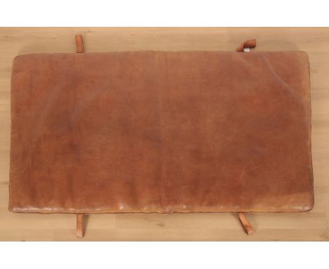 A GYMNASIUM MAT OR BENCH 'MATTRESS' 21st century, upholstered in tan leather, with four leather tabs, 6cm high x 185cm long x
