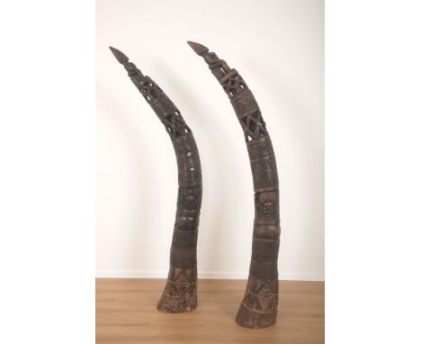 A PAIR OF AFRICAN CARVED HARDWOOD TUSK SCULPTURES 21st century, elaborately pierced and carved with figures amongst geometric