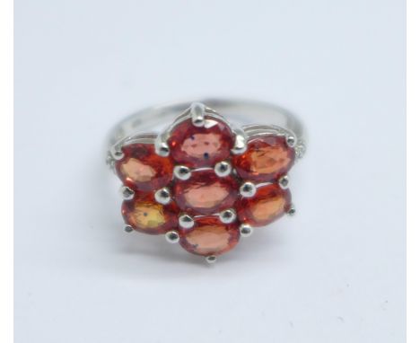 A 9ct white gold, hessonite garnet cluster ring, with diamond shoulders, 3g, K 