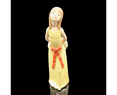 Glazed figural in yellow dress with rust sash, holding a hat. Lladro backstamp. Artist: Francisco CatalaIssued: 1978-1998Dime