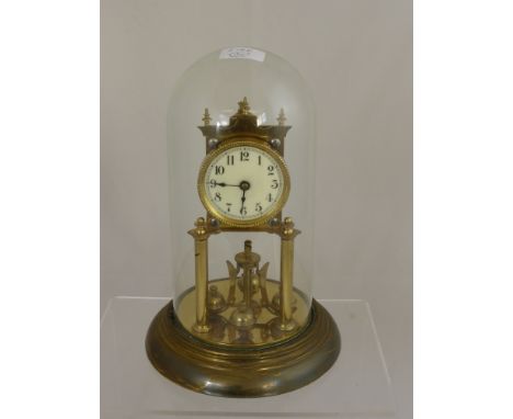 A Brass Anniversary Clock, with cream enamel face stamped DRGM No 403658 under a glass dome.