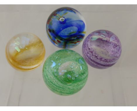 Three Caithness Paperweights of the Shimmer series, including green, purple, orange and Rainbox Gem.