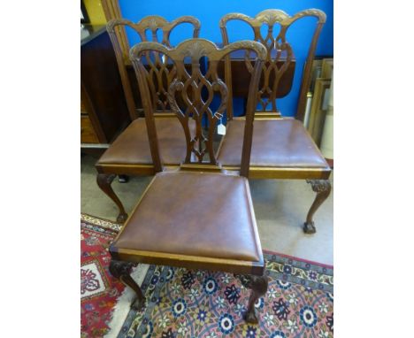 Five Chippendale style dining chairs and one carver, on ball and claw feet, with leather seats.