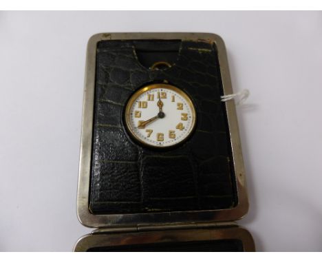 A Travelling Alarm Clock, in the original leather case,.