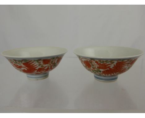 A pair of Chinese porcelain bowls depicting red phoenix in flight with chrysanthemum and scroll leaf design, everted rim, app