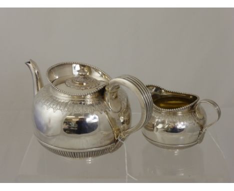 A Solid Silver Teapot, London hallmark, both being of rib design with foliate engraving and beaded rim, dated 1891/92, m.m Ri