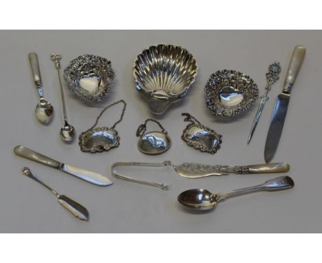 A collection of sterling silver and white metal tableware. To include two pierced work heart shaped bonbon dishes, a scallop 